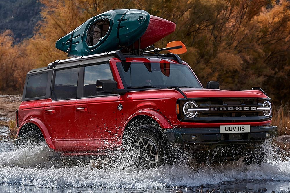 Ford Bronco rouge roulant dans l'eau