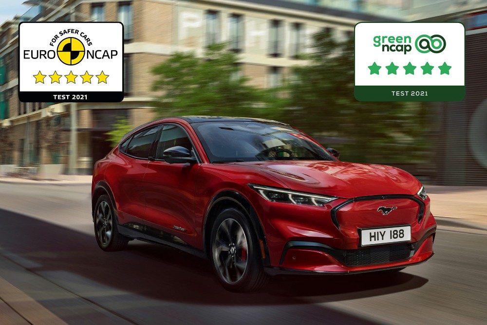 Une Mustang Mach-E rouge circule sur une route ; les logos des distinctions de sécurité NCAP sont superposés à l'image.