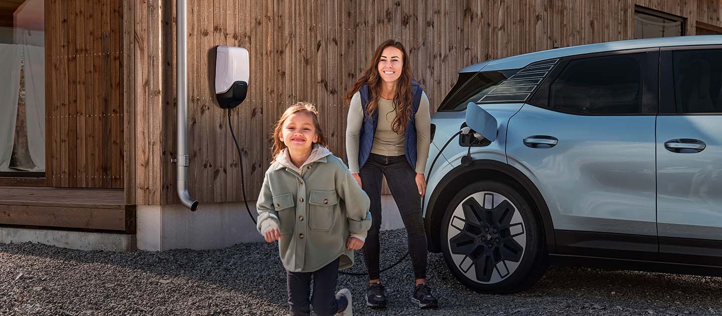 Une famille s'amuse tout en rechargeant leur Ford Explorer électrique à la maison.