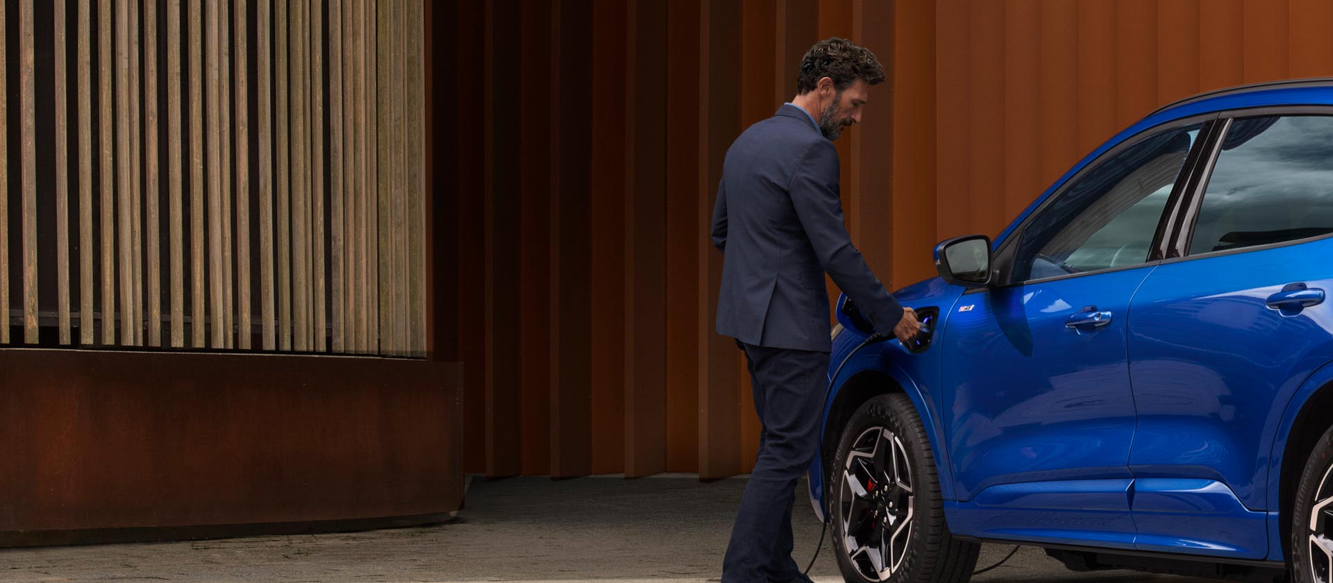 Une personne connectant une voiture Plug-in Hybrid Ford à un câble de recharge domestique VE.