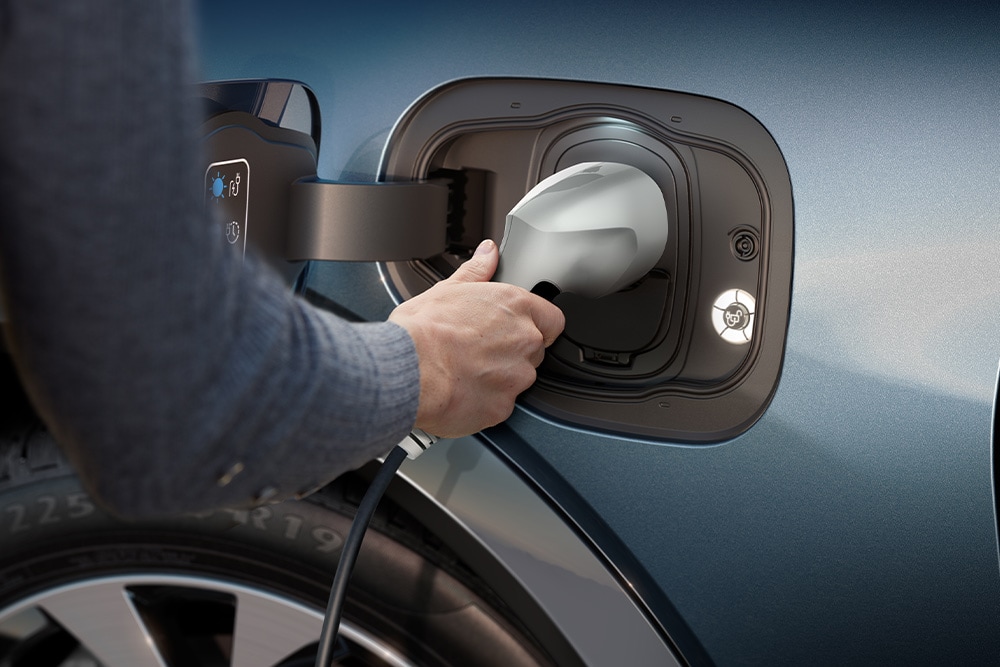 Gros plan d’une personne en train de charger un véhicule électrique Ford.