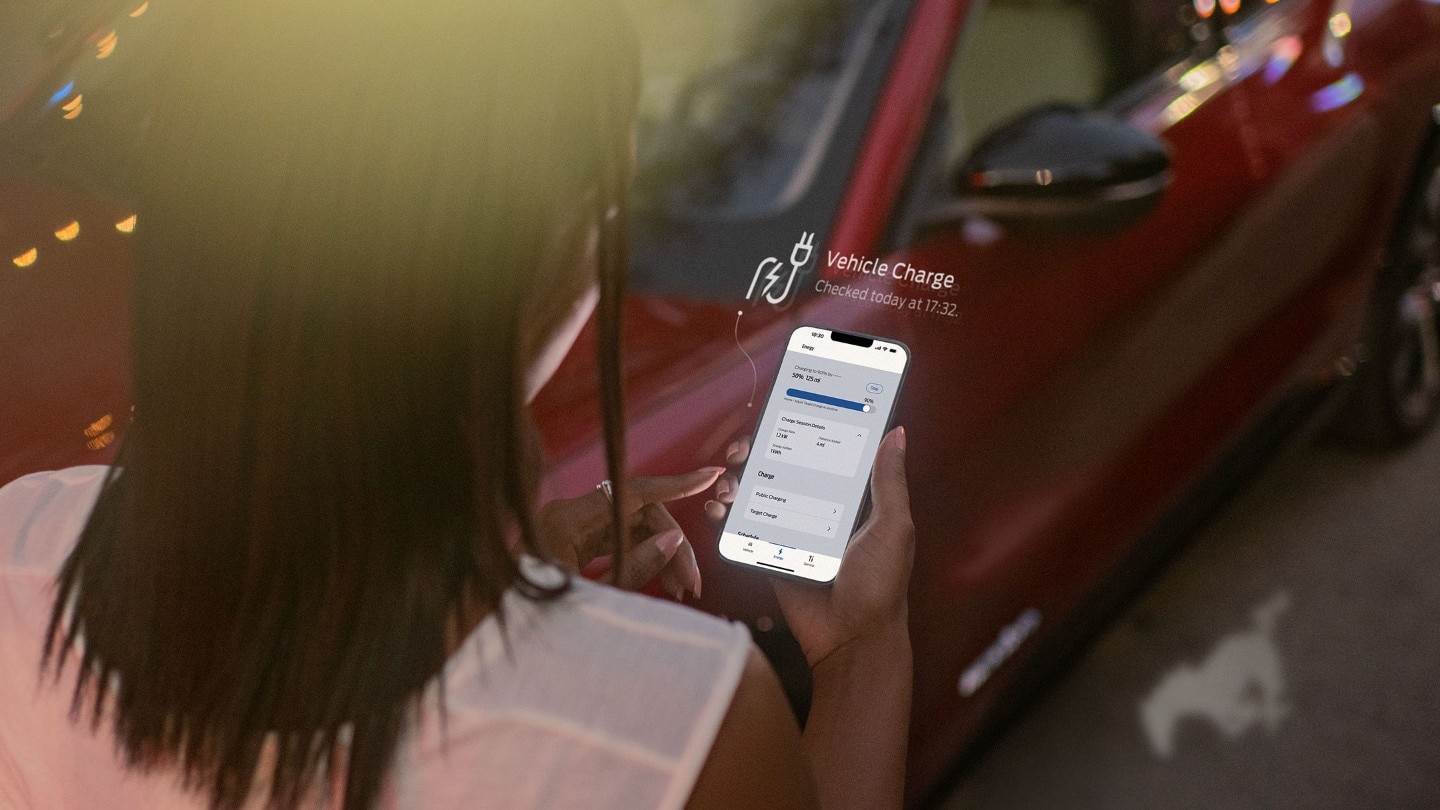 Person using FordPass by a Red Ford Mustang Mach-E