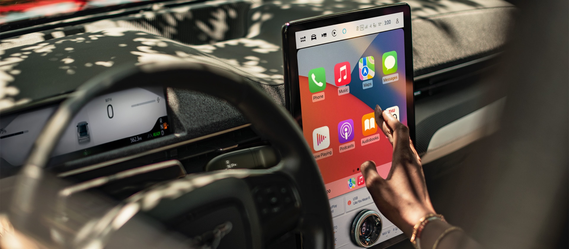 Gros plan sur le conducteur d’une Ford Mustang Mach-E utilisant le grand écran tactile SYNC 4 de 15,5" et Apple CarPlay. 