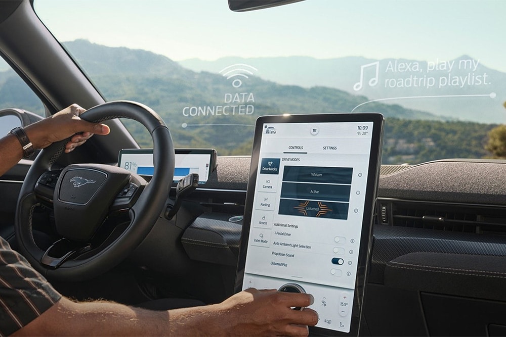 Gros plan sur le conducteur d'une Ford Mustang Mach-E qui interagit avec le grand écran tactile SYNC 4 de 15,5 pouces.