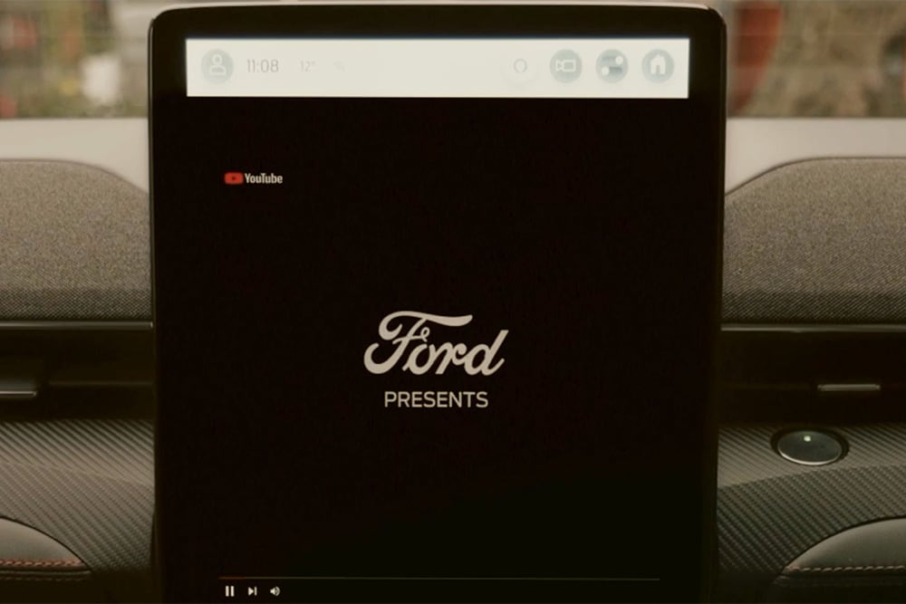 Gros plan de l’écran tactile SYNC 4 de 15,5" affichant le message « Ford présente », pour montrer le streaming vidéo embarqué