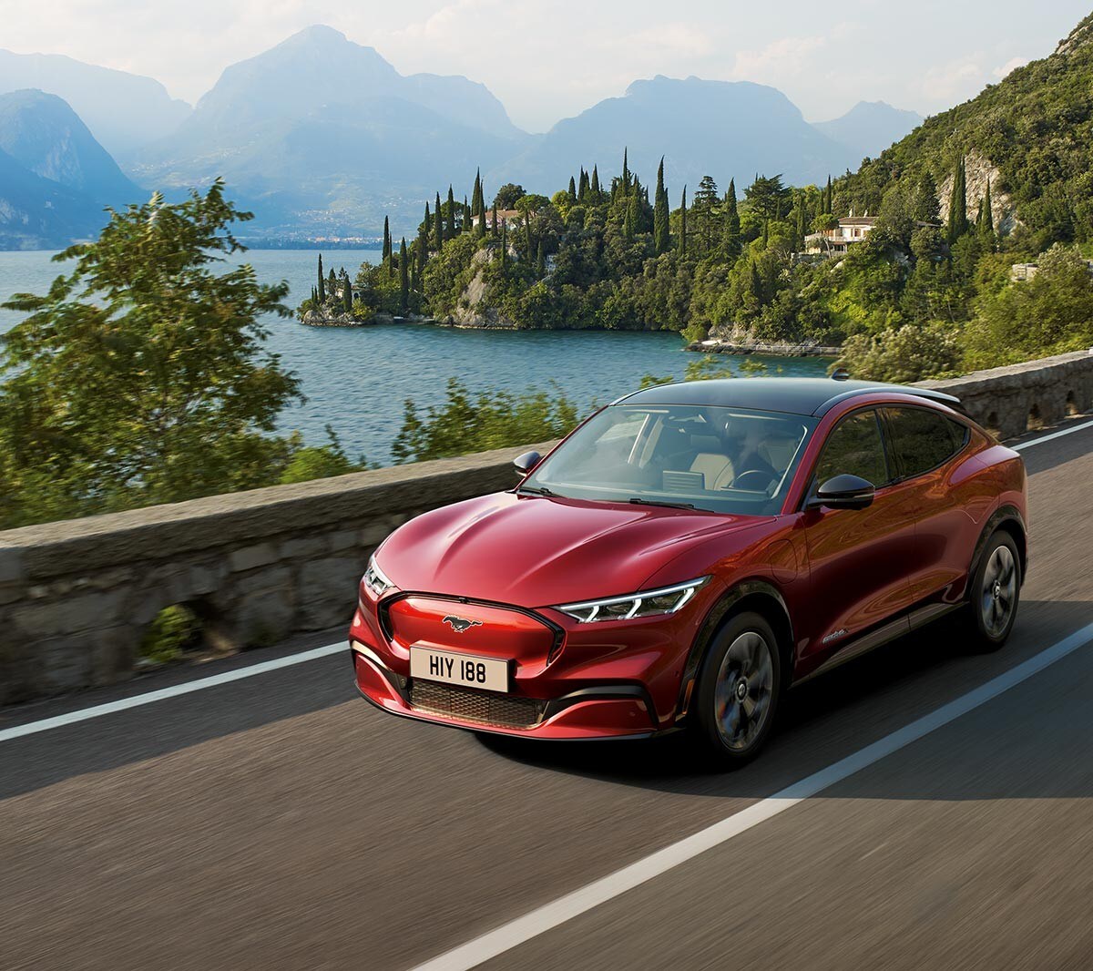 All-New Ford Mustang Mach-E driving past lake in mountains
