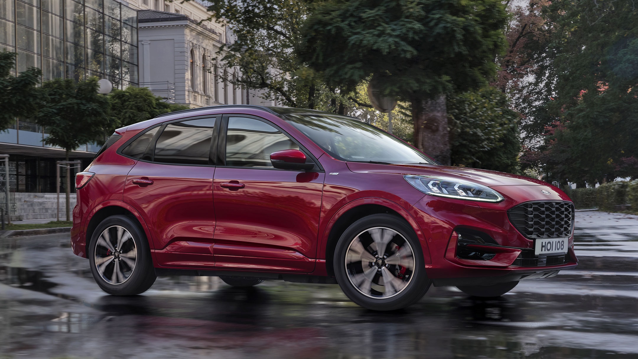 New Red Ford Kuga driving on wet road