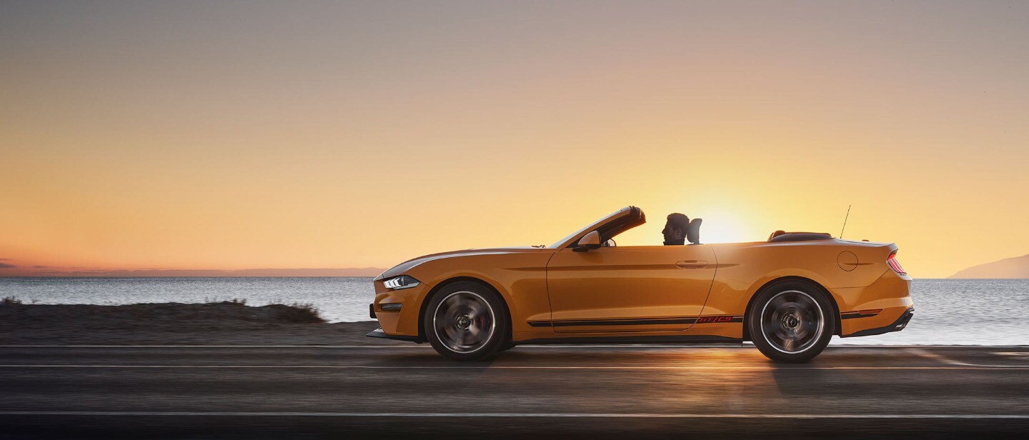 Ford Mustang California Edition driving down a highway against a sunset