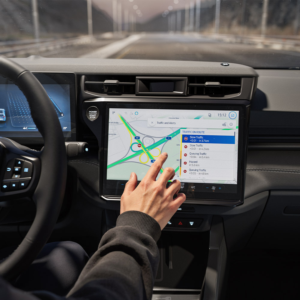 Un conducteur utilisant la fonctionnalité de Navigation Connectée sur l’écran numérique d’un Ford Puma Gen-E BlueCruise Edition.