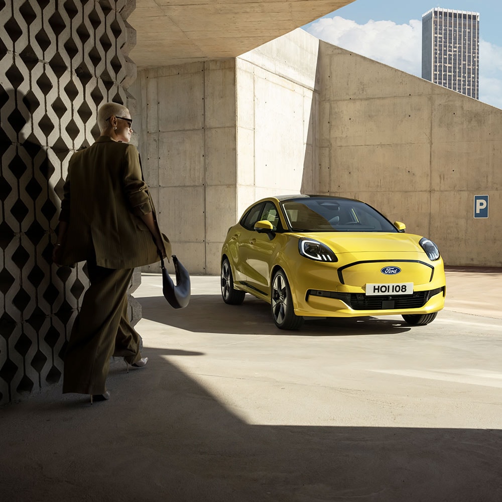 Une personne s’avance vers le nouveau Ford Puma Gen-E® électrique en jaune.