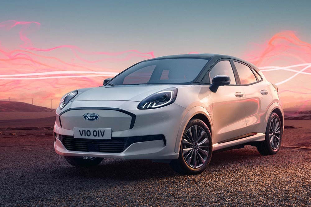 Le modèle Ford Puma Gen-E Sound Edition en blanc, garé avec des ondes sonores rouges en arrière-plan.