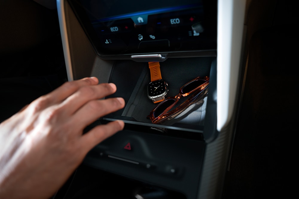 Une main se dirige vers le compartiment My Private Locker (casier secret) dans le Ford Capri®, dévoilant une montre et une paire de lunettes de soleil à l’intérieur.