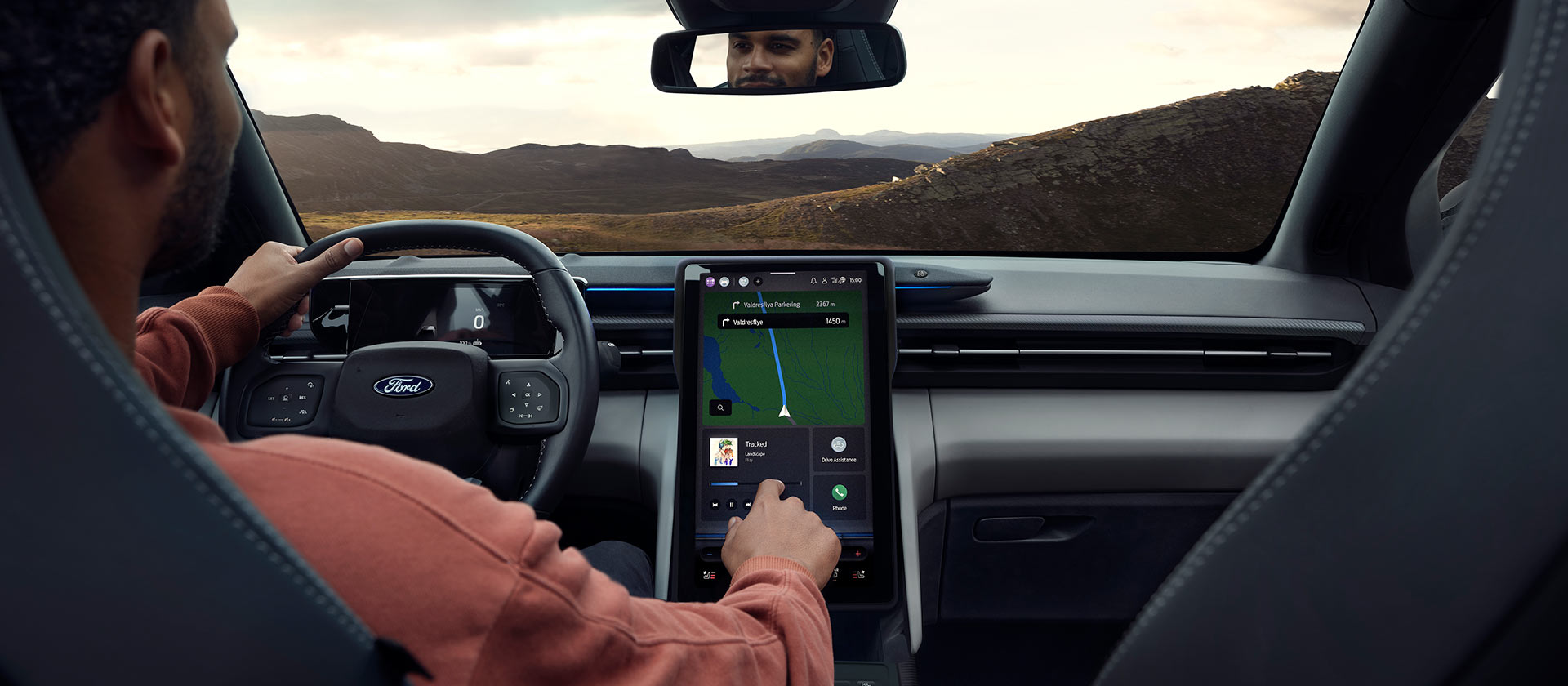 Une personne conduisant le Ford Explorer électrique sur une route de campagne et réglant la musique sur le grand écran tactile SYNC Move de 14,6 pouces.