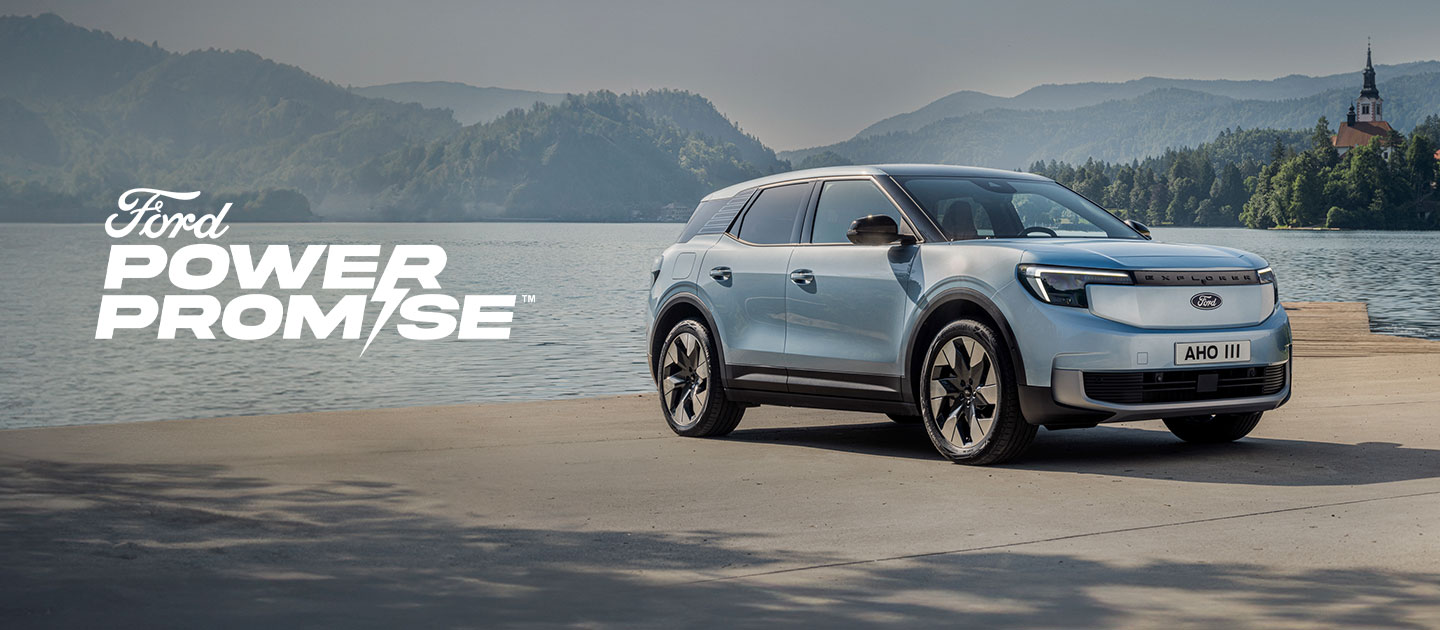 Le nouveau Ford Explorer® 100% électrique en peinture bleu arctique, garé au bord d'un lac.