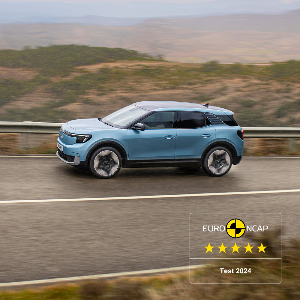 Un Ford Explorer bleu roulant sur une route de montagne, avec le logo Euro NCAP cinq étoiles 2024 dans le coin supérieur gauche.