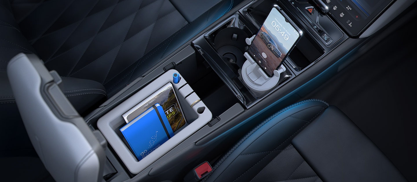 L'espace de rangement intérieur de la MegaConsole, accueillant un ordinateur portable et un support de téléphone portable.