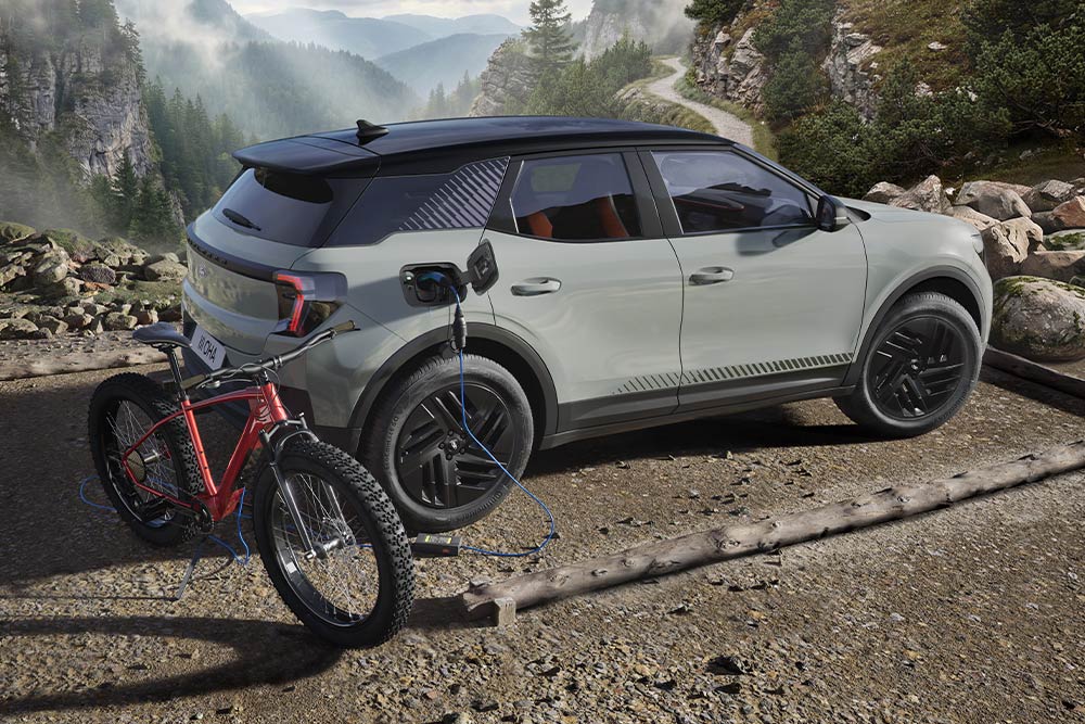 Un Ford Explorer recharge un vélo électrique dans un paysage montagneux.