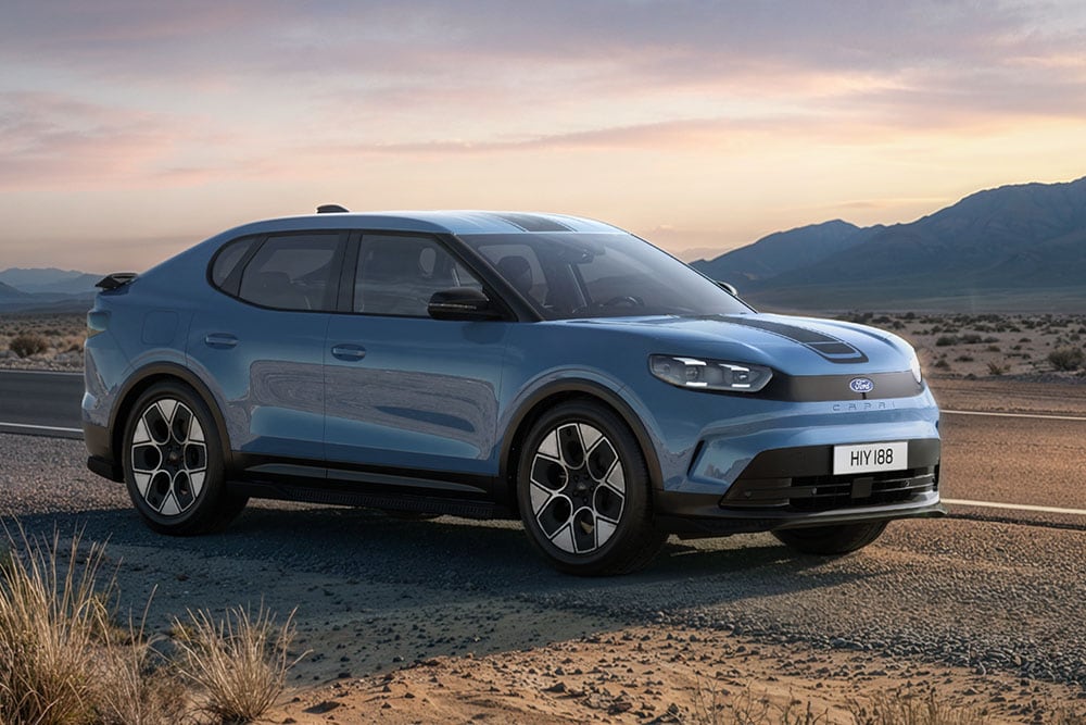 Ford Capri® Collection bleu  circulant sur une route de montagne poussiéreuse.