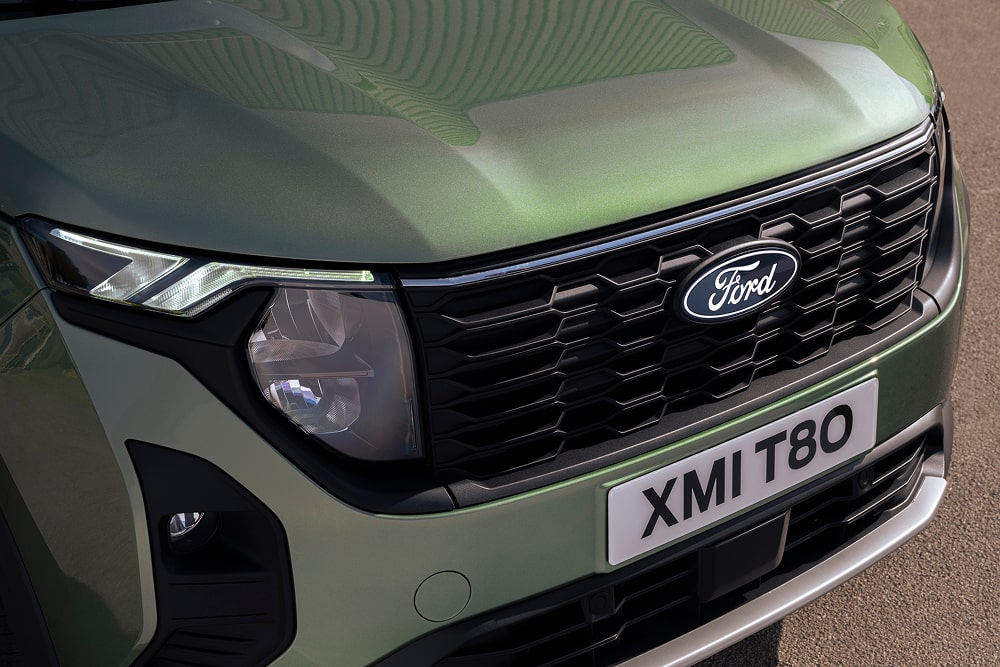 Détail de la calandre et des phares d’un MPV Ford Tourneo Courier vert.