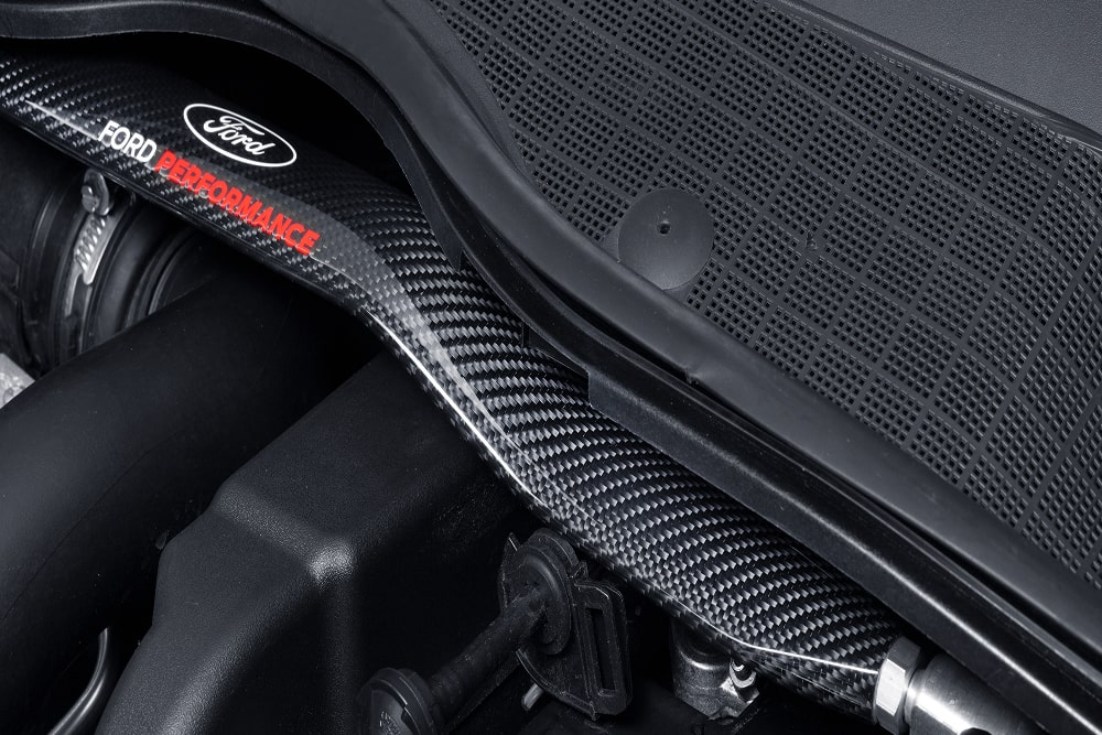 Gros plan sur un composant moteur d’une voiture Ford Performance, dans le compartiment moteur.