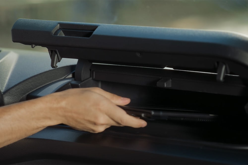 Une main pénètre dans un compartiment au-dessus du siège du conducteur dans le Ford Tourneo Custom.