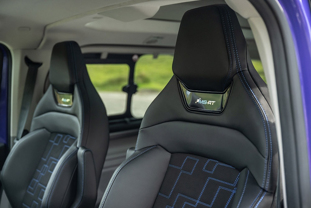 Sièges avant en cuir noir et daim, avec des surpiqûres bleues contrastantes et le logo MS-RT dans un Ford Tourneo Custom MS-RT.