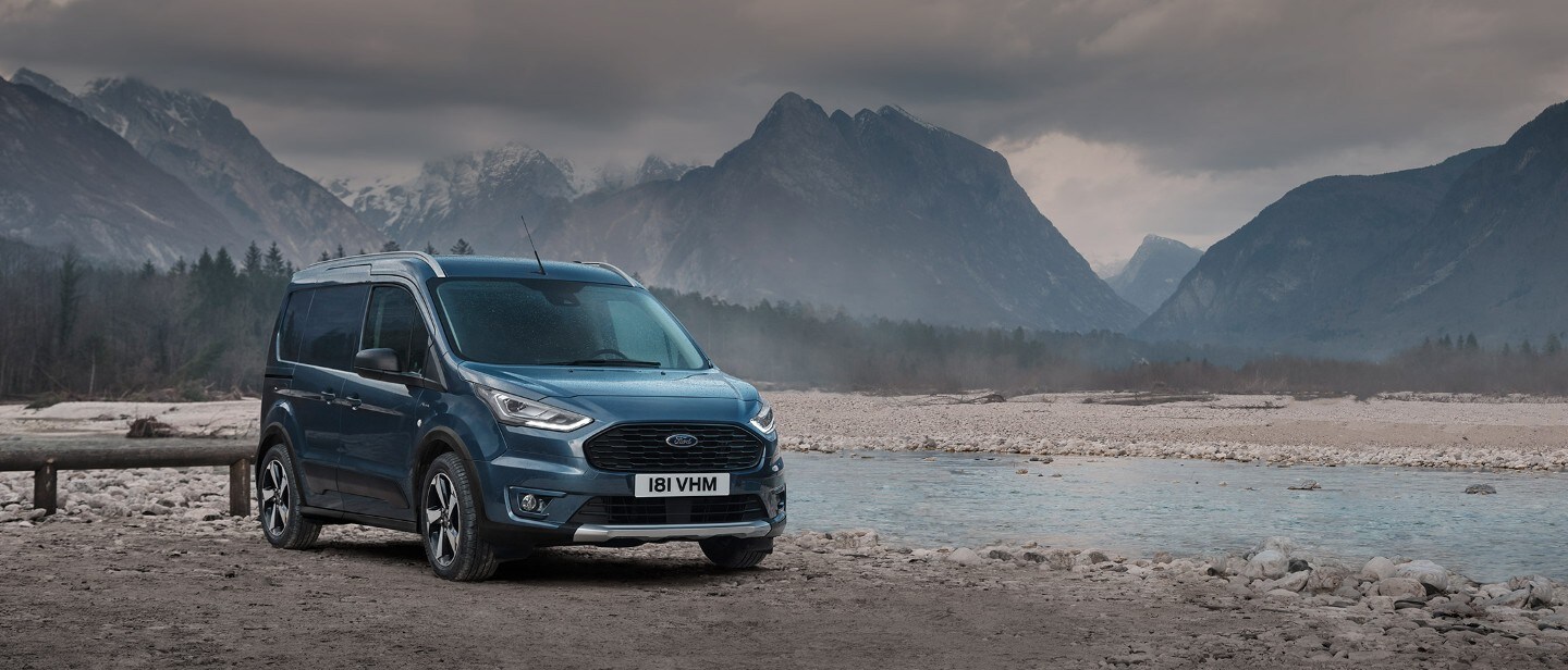 Ford Transit Connect standing by lake in mountains