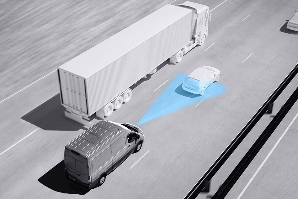Dessin en niveaux de gris d’un fourgon Ford Transit avec des lignes bleues sur la route illustrant l’utilisation de systèmes avancés d’aide à la conduite.