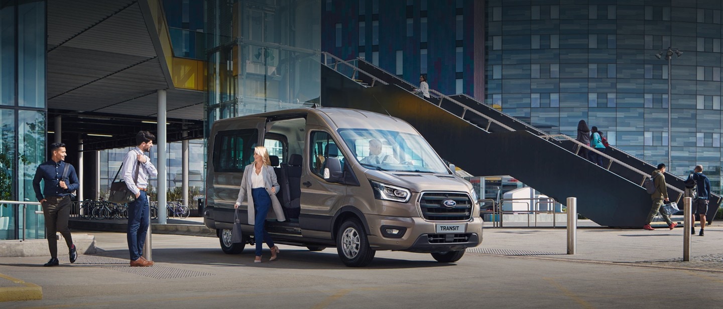 All New Ford Transit Minibus parked outside glass building All New Ford Transit Minibus parked outside glass building