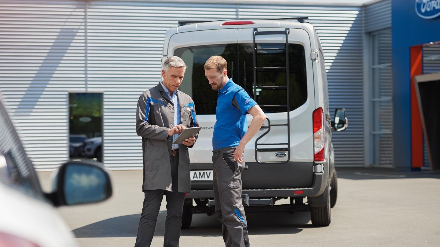 Service person and a Ford E-Transit owner discussing paperwork at the back of E-Transit