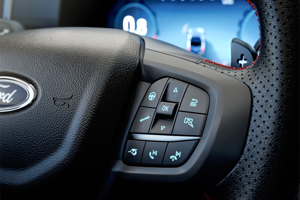 Gros plan sur le volant du Ford Ranger Raptor, centré sur son bouton R.