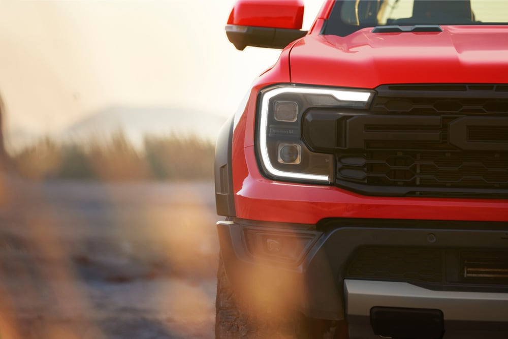 Gros plan sur la calandre d'un Ford Ranger Raptor rouge.