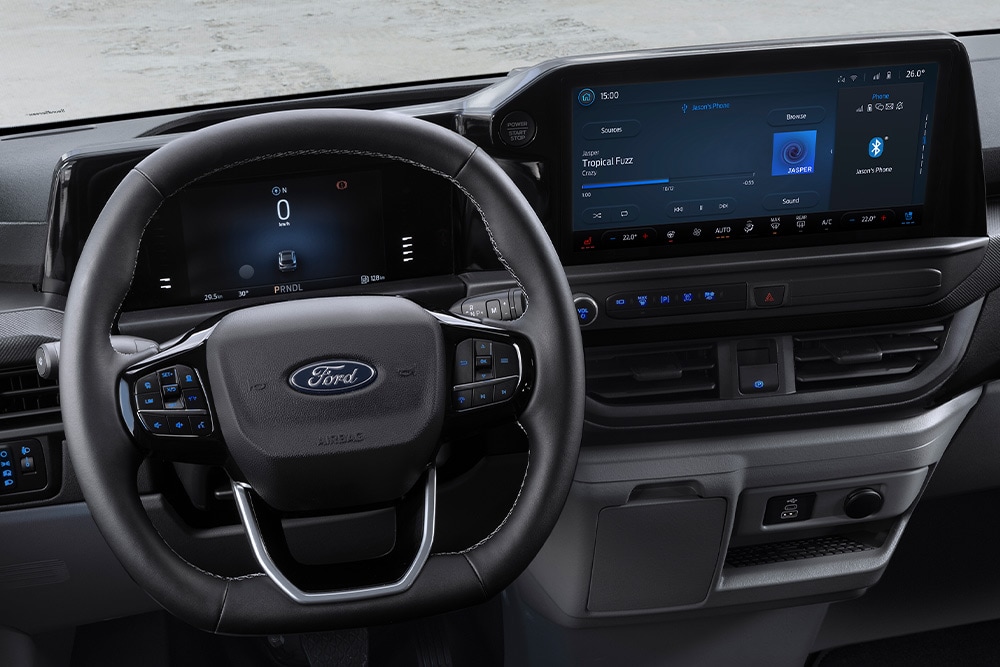Vue intérieure du volant et du tableau de bord d'un Ford Transit Custom.
