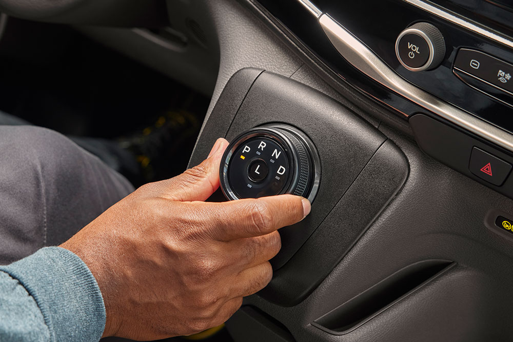 Gros plan sur une main tournant le sélecteur de vitesse dans un fourgon électrique Ford E-Transit.