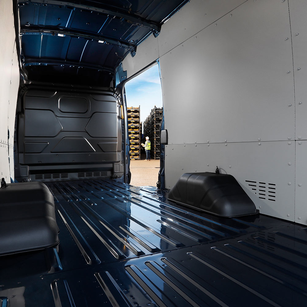 Intérieur d’un fourgon électrique Ford E-Transit avec un espace de chargement vide.