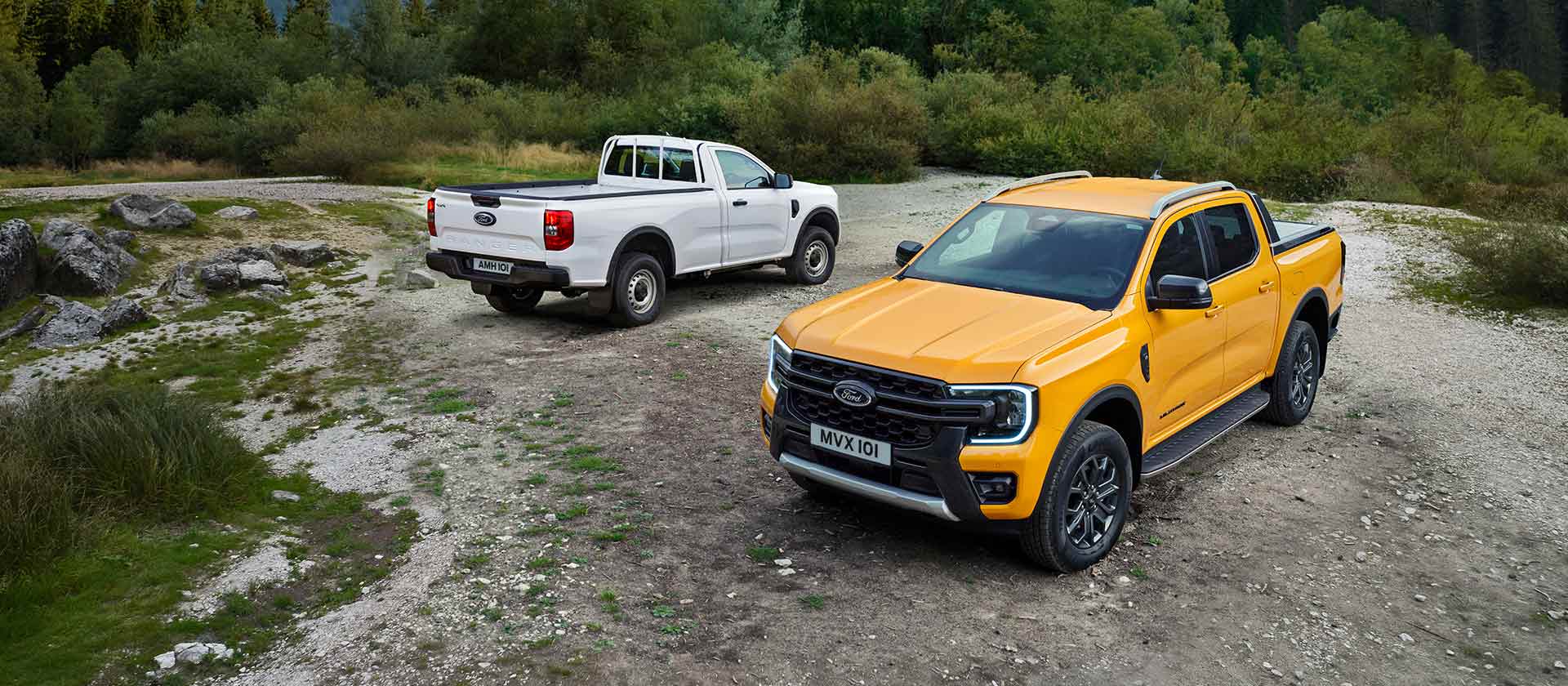 Un Ford Ranger blanc et un Ford Ranger jaune sont garés sur un côté rocheux de la route. (Simple Cabine non disponible en Belgique/Luxembourg)