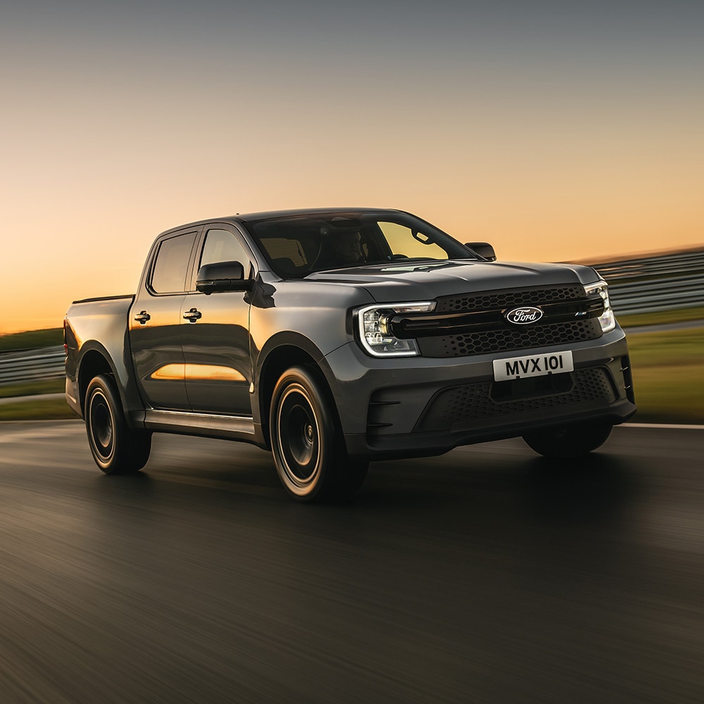 Ford Ranger MS-RT gris roulant sur une piste au coucher du soleil.