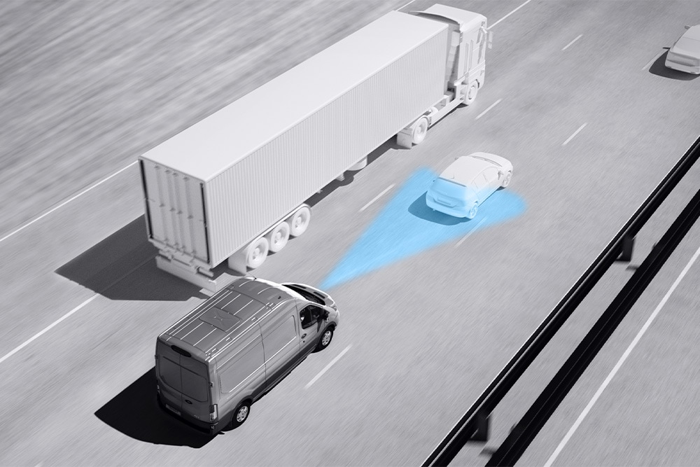 Dessin en niveaux de gris d’un fourgon Ford Transit avec des lignes bleues sur la route illustrant l’utilisation de systèmes avancés d’aide à la conduite.