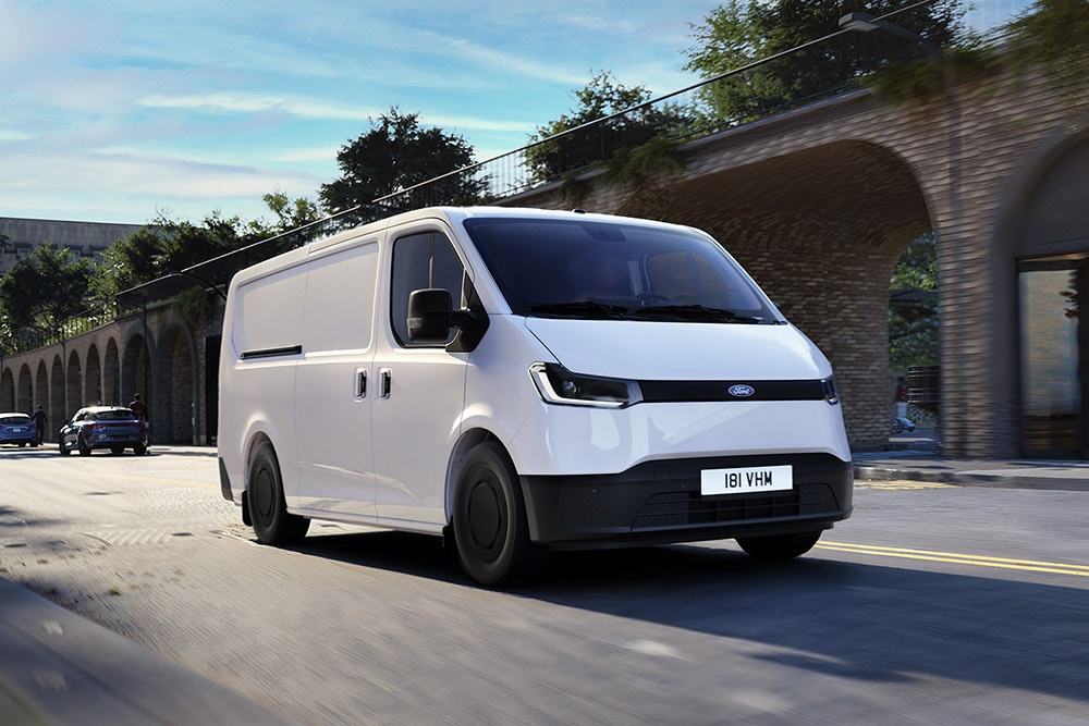 Un fourgon Ford Transit City® L1H1 blanc circule dans une rue de la ville.