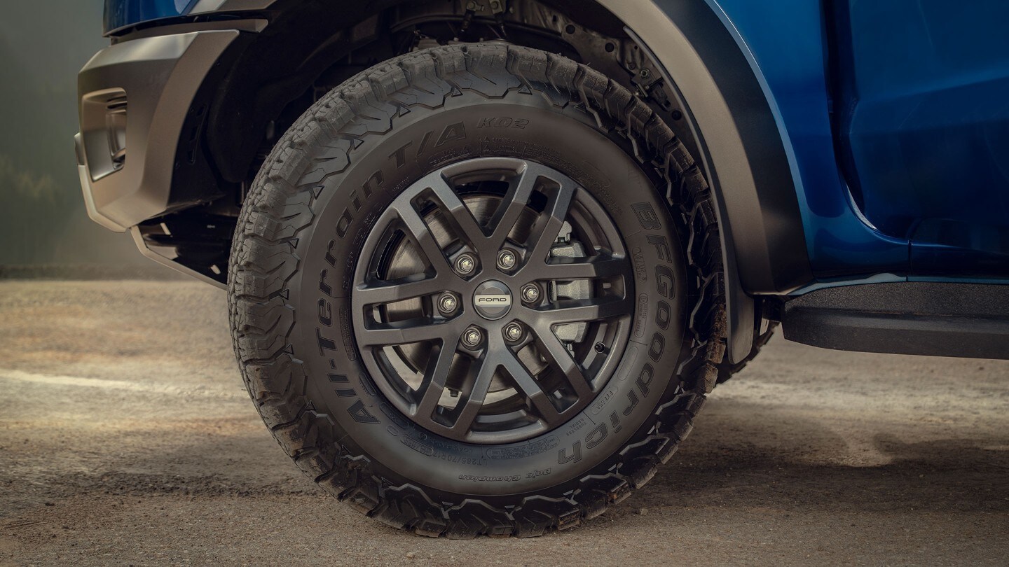 Blue Ford Ranger Raptor driving on rural road