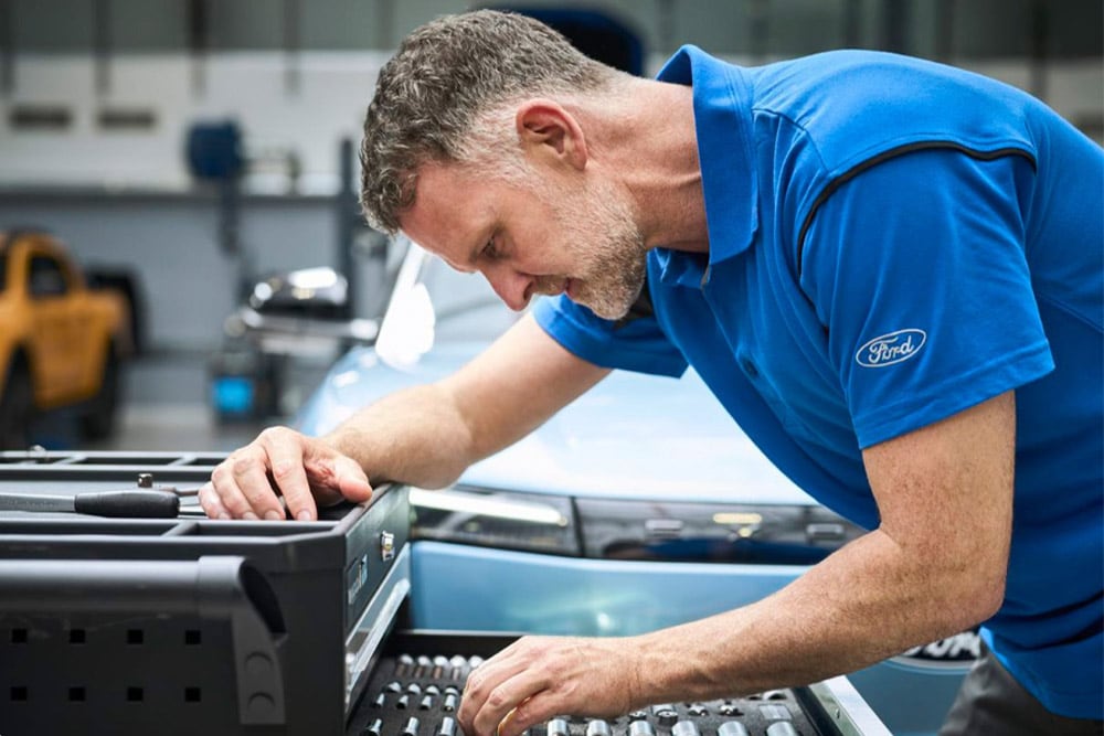 Gros plan sur un technicien agréé Ford travaillant dans un garage.