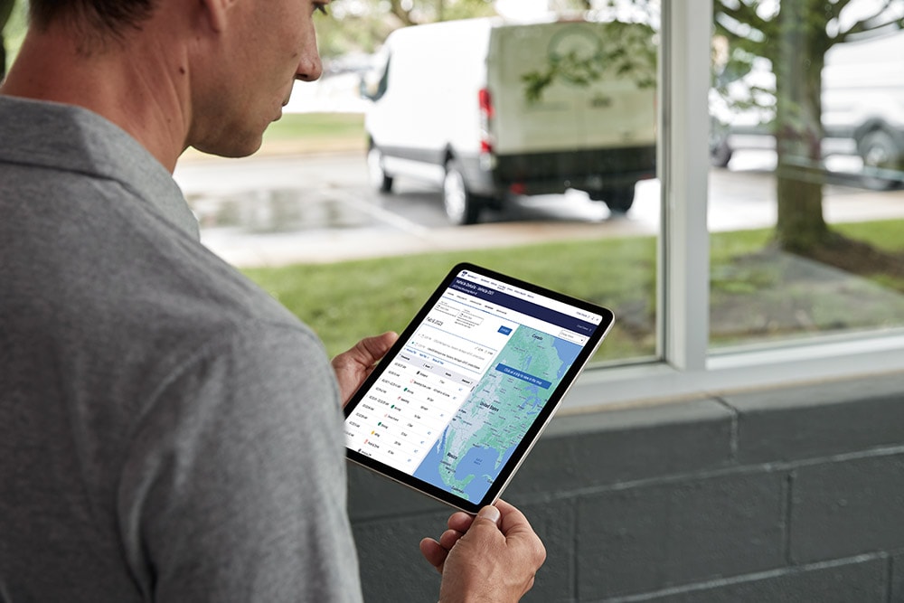 Un homme consulte les données de son véhicule Ford sur une tablette, les surveillant en direct.