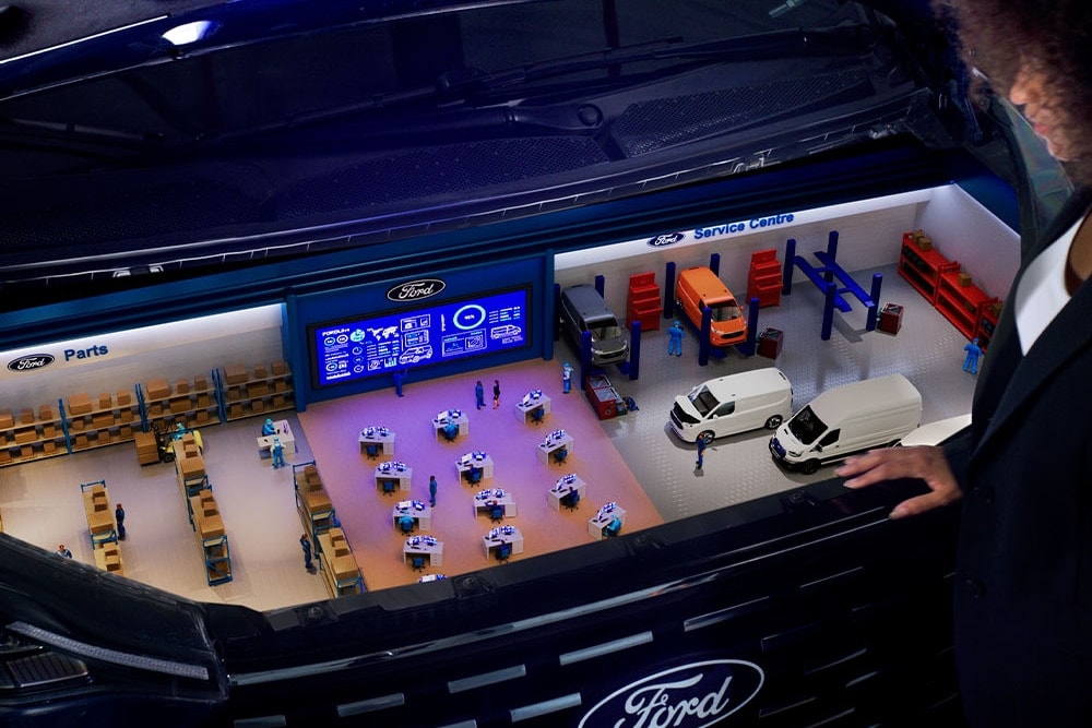 Modèle miniature d'un centre de service Ford à l'intérieur d'un coffre de voiture.