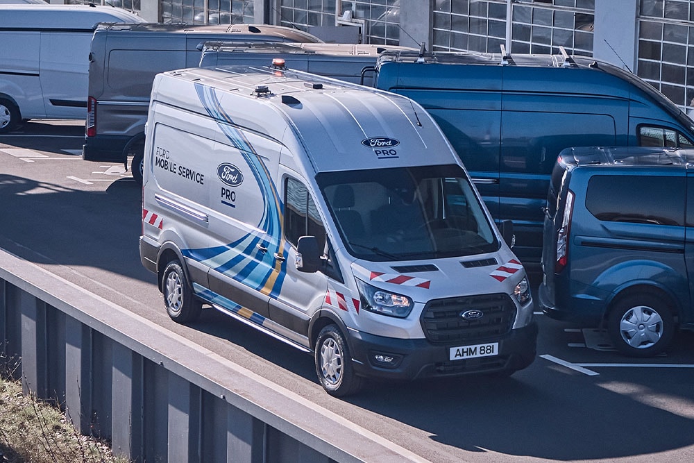 Une camionnette Ford Mobile Service roule sur l'autoroute aux côtés d'autres véhicules.