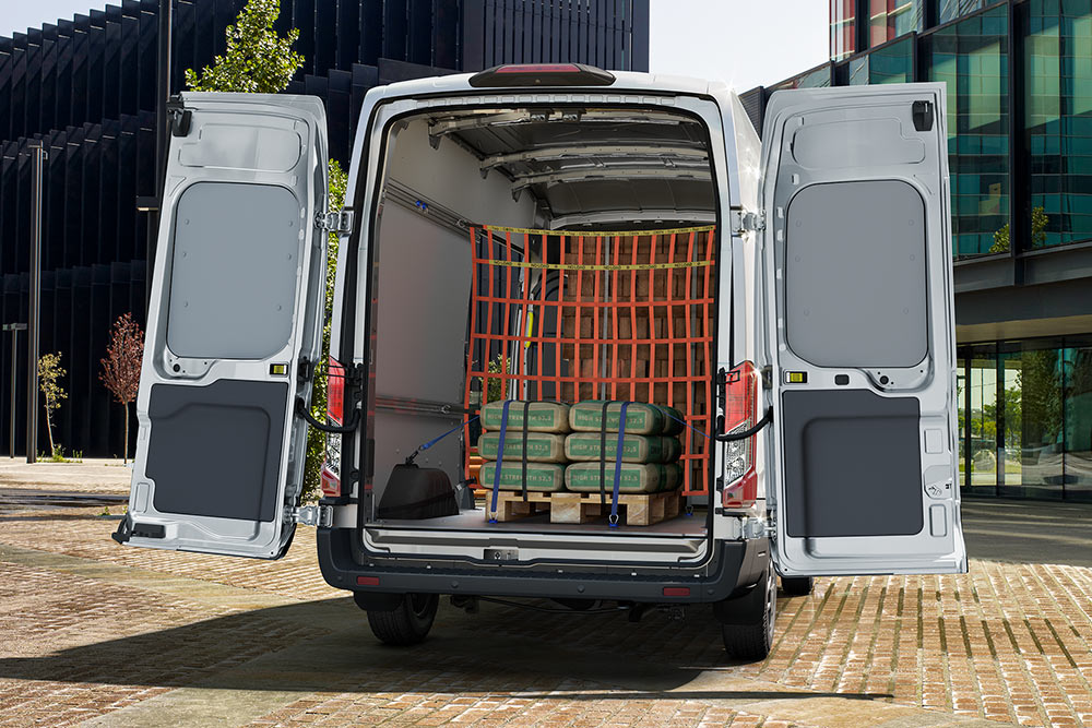 Vue arrière de l'intérieur d'une camionnette Ford blanche garée près de bureaux.