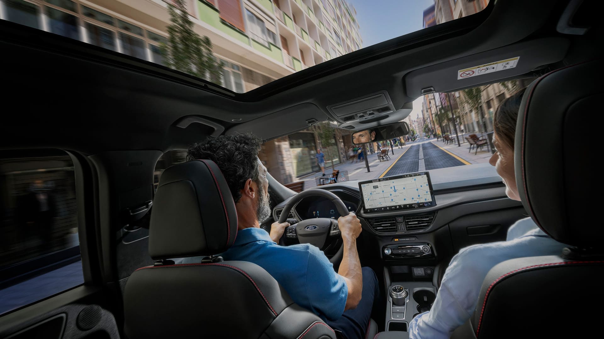 Passagers d'un véhicule Ford avec l'écran numérique SYNC  pour aider à naviguer en ville.
