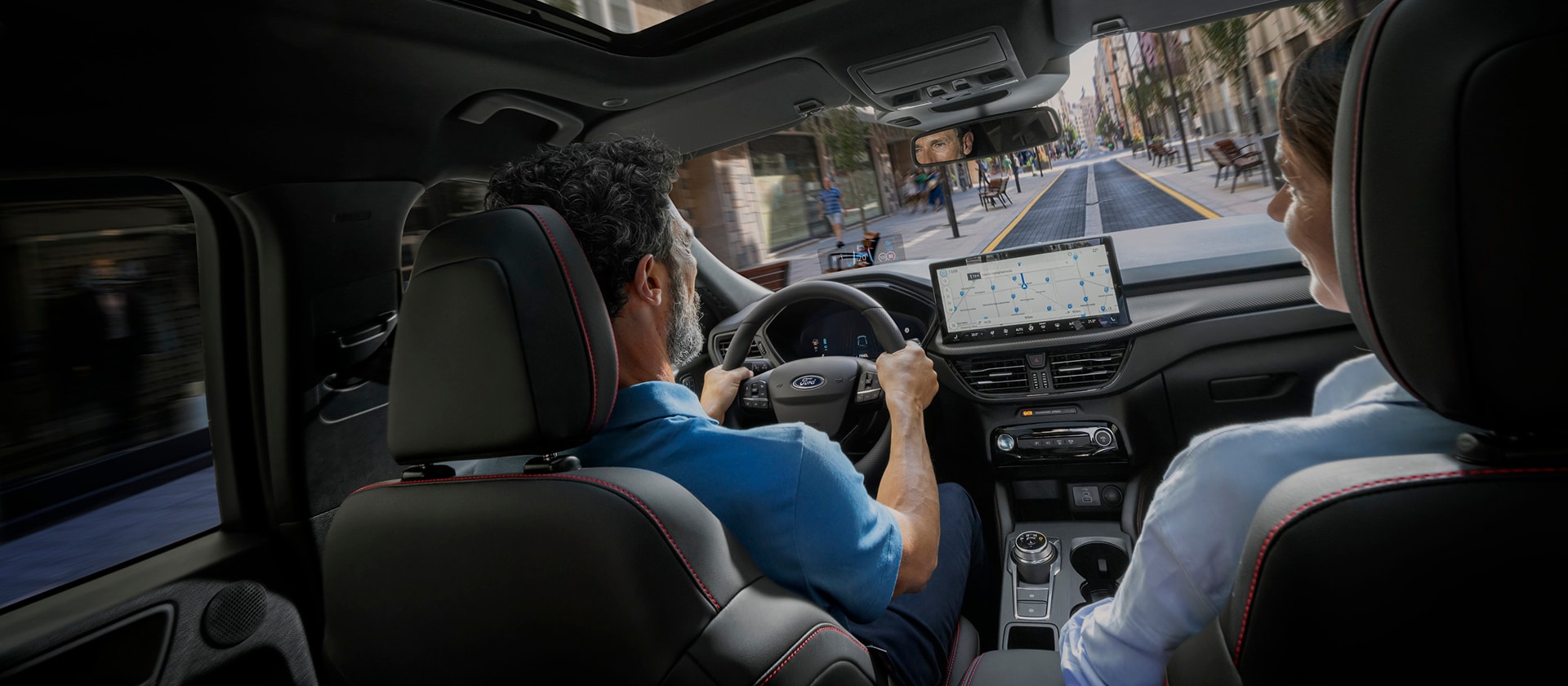 Passagers d'un véhicule Ford avec l'écran numérique SYNC  pour aider à naviguer en ville.