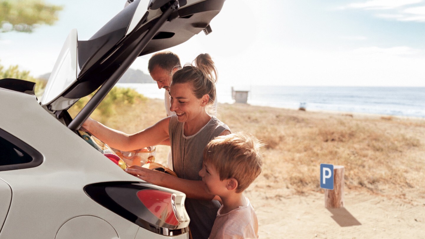 Une famille à la plage charge des affaires dans le coffre d'un véhicule Ford.